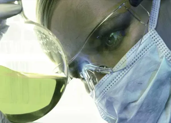 Trabajador de laboratorio examinando una muestra líquida