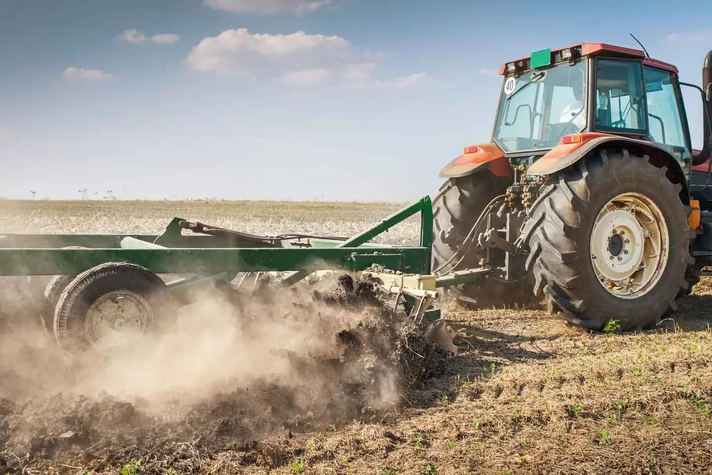 Tractor cultivating dry soil in a field